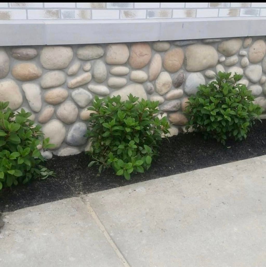 River-rock stone veneer applied to a home's foundation wall.
