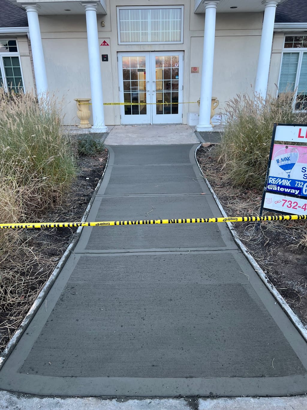 Finished concrete walkway approach to a commercial entrance.